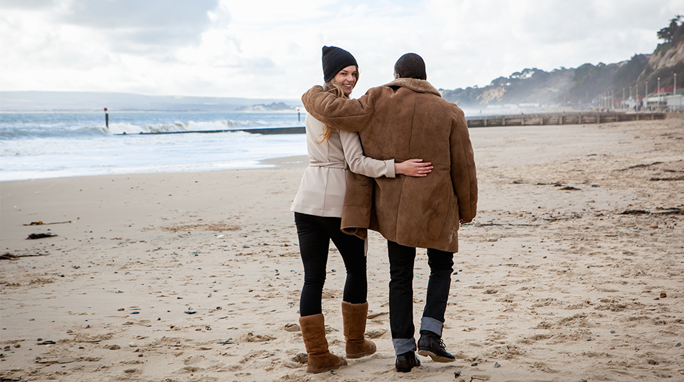 Young couple strolling on beach, Bournemouth, Dorset, UK
